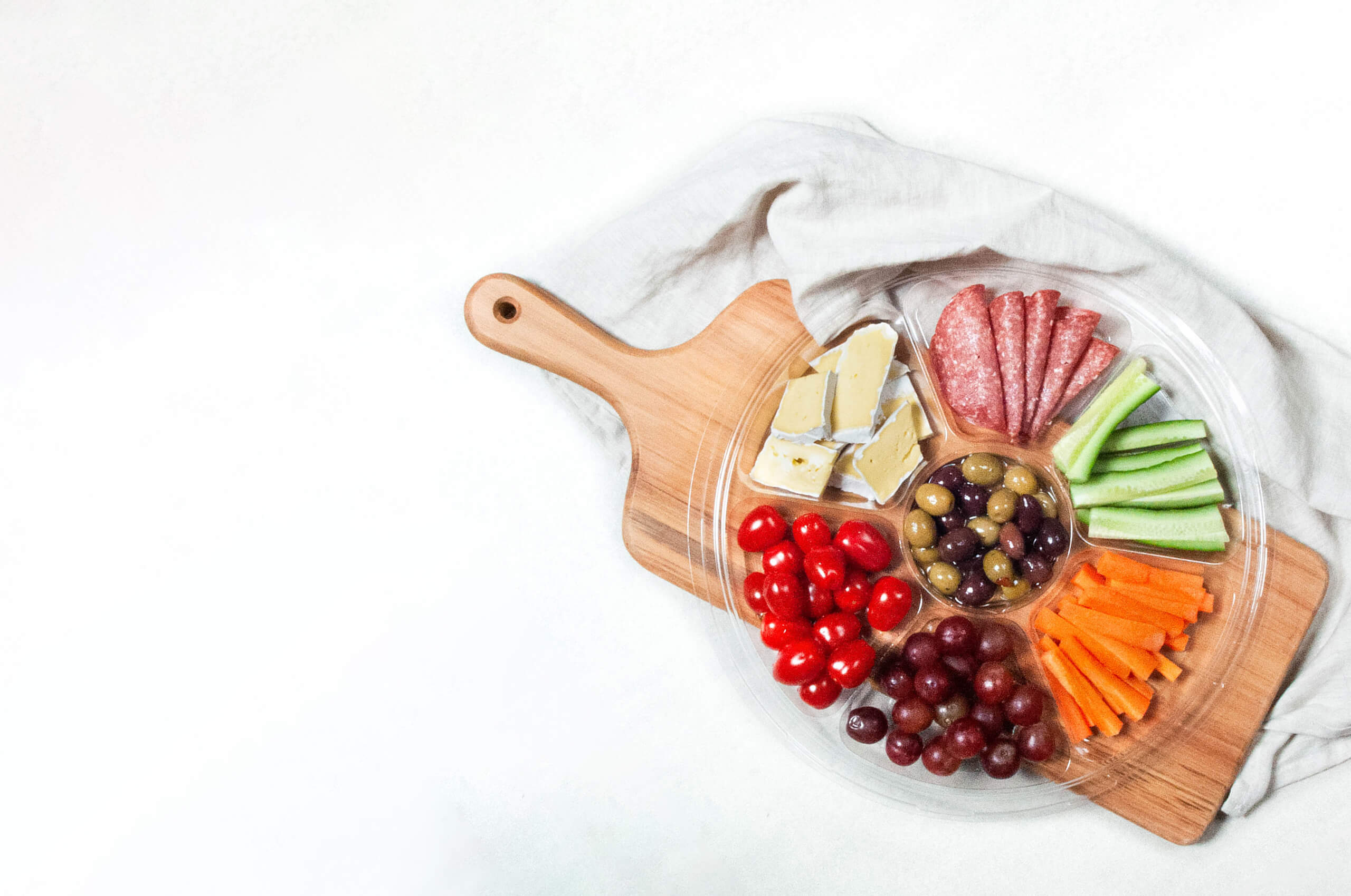 plastic platter tray on chopping board with off white tea towel