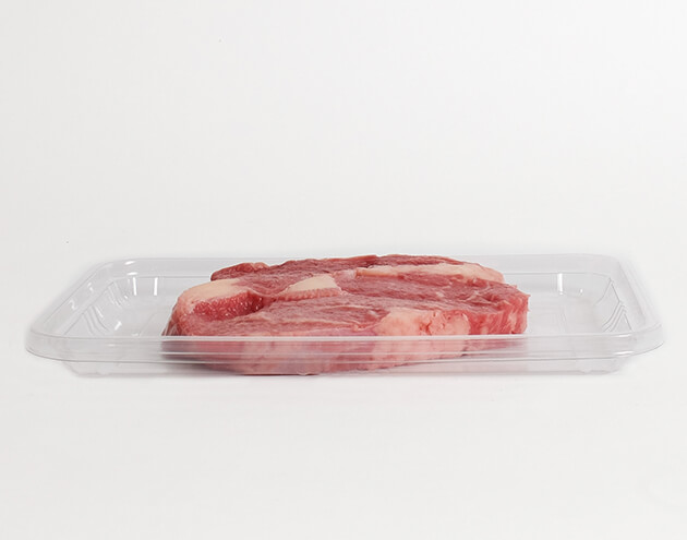 packaged meat in plastic container with white background