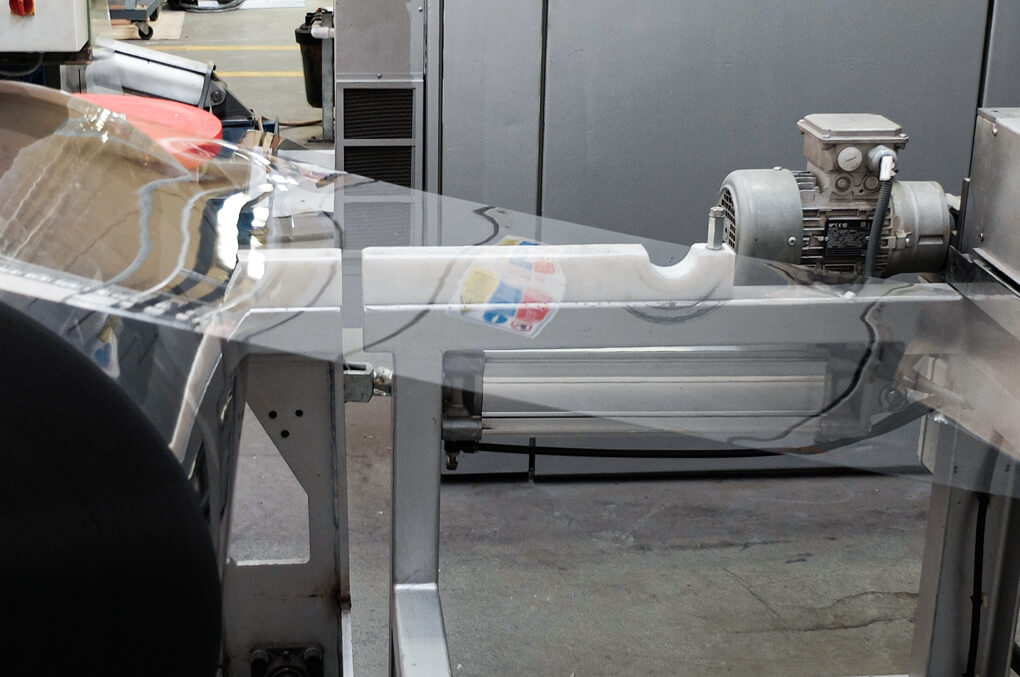 Plastic film being processed through industrial machinery at CustomPak NZ, showcasing precision manufacturing for custom recyclable packaging.”